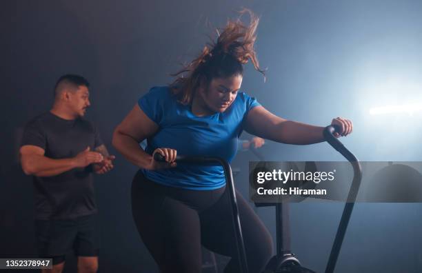 shot of a young woman working out with an exercise bike in a gym - friends studio shot stock pictures, royalty-free photos & images