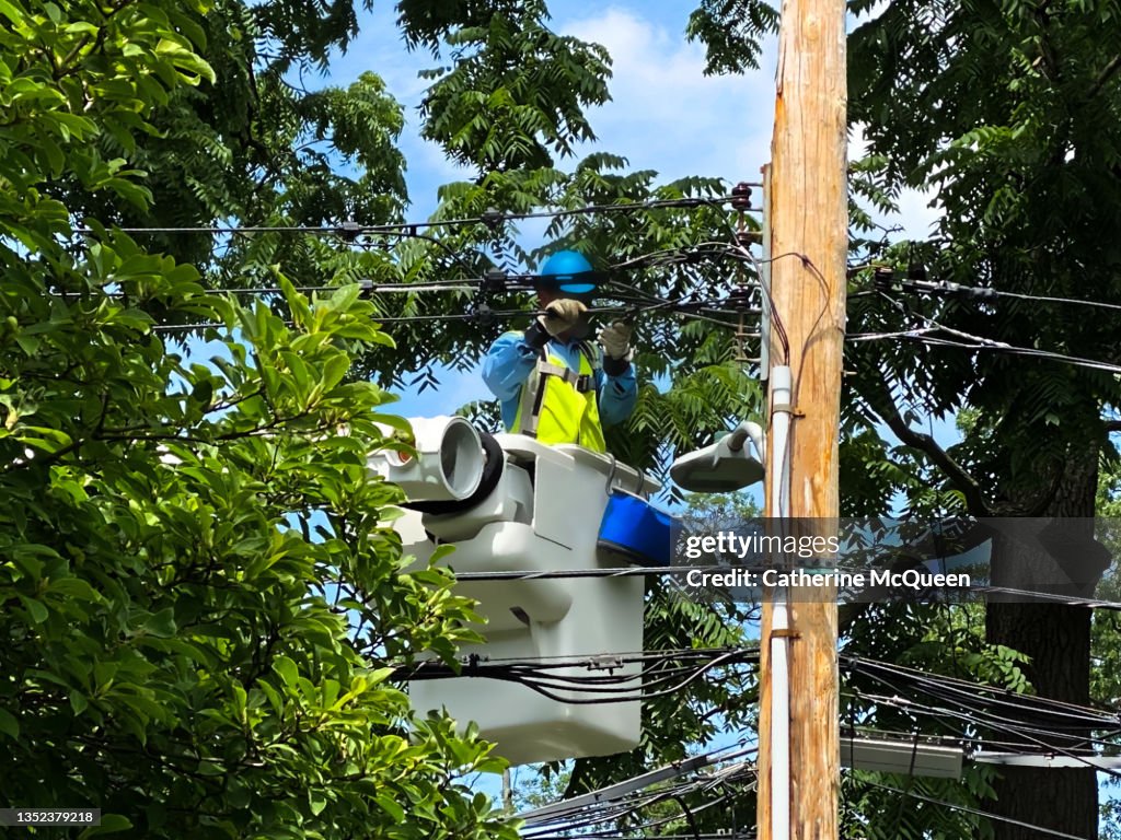 Electric company utility worker repairing power lines during power outage
