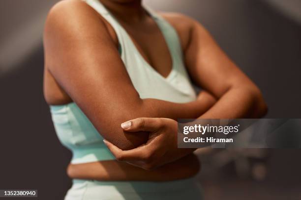 shot of a woman experiencing elbow pain while working out in a gym - 肘 個照片及圖片檔