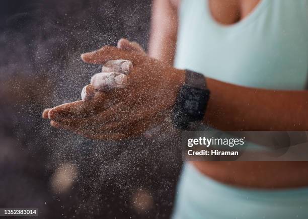 shot of an unrecognisable woman dusting her hands with chalk while working out in a gym - hard talk stockfoto's en -beelden