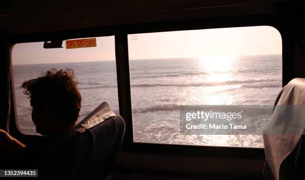 Passenger rides an Amtrak train passing near the Pacific Ocean on November 9, 2021 near Oceanside, California. The newly passed $1.2 trillion Biden...