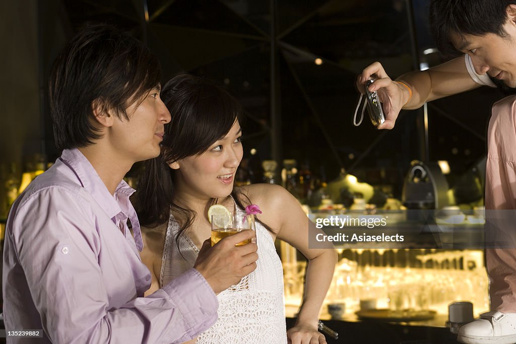 Young man photographing a young couple