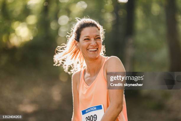 happy female marathon runner in nature. - half marathon stock pictures, royalty-free photos & images
