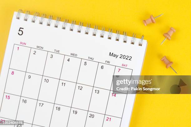 calendar desk 2022 on may month, the concept of planning and push pin on calendar date with yellow background. - may - fotografias e filmes do acervo