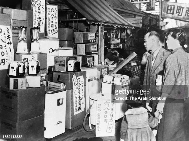 In this undated photo, shoppers examine home appliances such as washing machine, television sets and fridges circa 1956 in Tokyo, Japan.