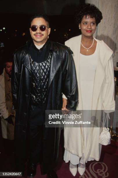 American actor Darryl M Bell, wearing a black leather overcoat and a quilted jacket, holding hands with American actress Tempestt Bledsoe, wearing a...