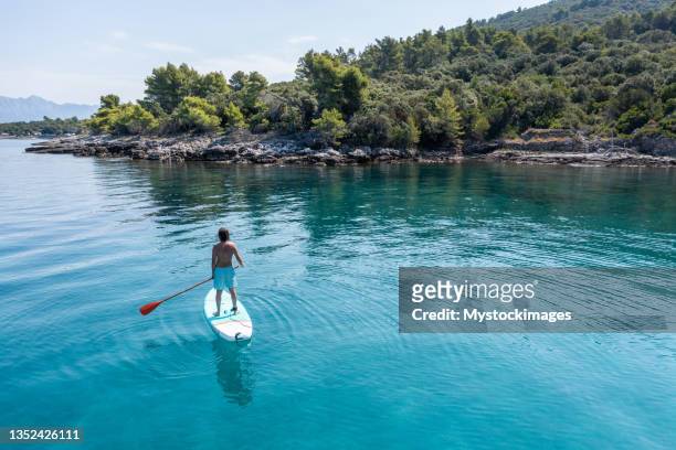 drone view of man on a stand up paddle in croatia - sup stockfoto's en -beelden