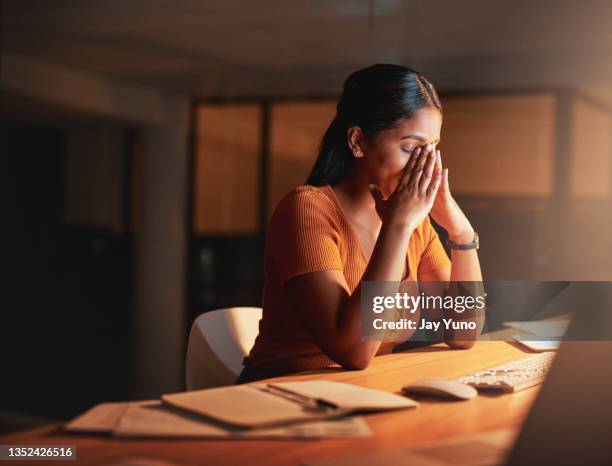 夜にオフィスに一人で座ってストレスを感じている魅力的な若いビジネスウーマンのショット - 神経衰弱 ストックフォトと画像