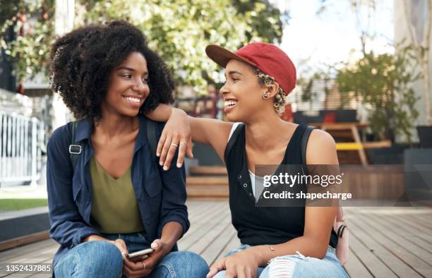 foto de dos jóvenes amigos teniendo una conversación interesante afuera - lesbian couple fotografías e imágenes de stock