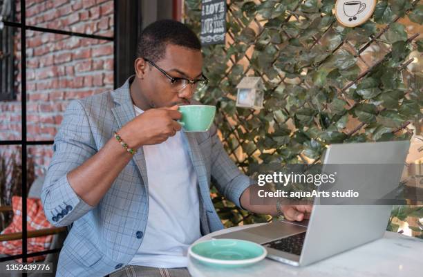 male freelancer at coffee shop - high tech beauty stockfoto's en -beelden