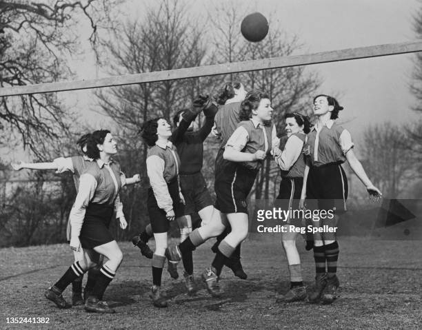 Footballers for the Hayes United Women's Football Club practice heading the ball during a training session on 12th February 1938 at the playing...