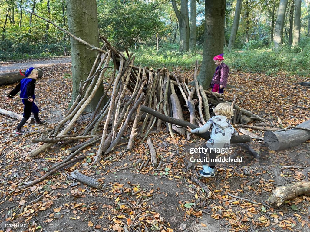 Children making a hut with campfire