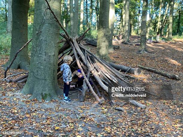 children making a  hut with campfire - hut stock pictures, royalty-free photos & images
