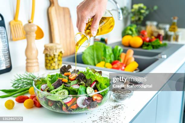 dressing salad with olive oil - grönsallad bildbanksfoton och bilder