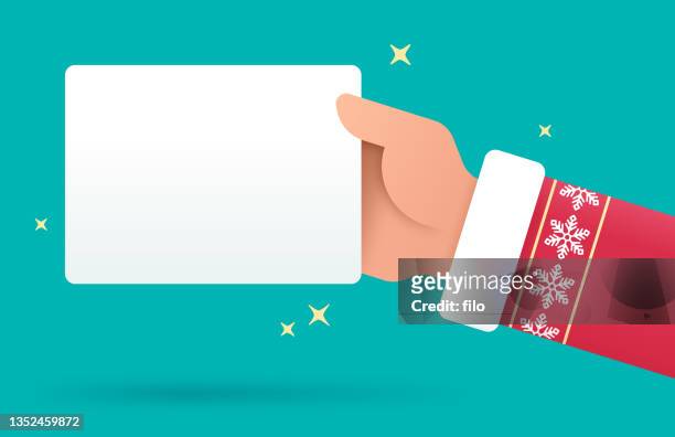 santa christmas holiday hand holding gift card or sign - hand holding card stock illustrations