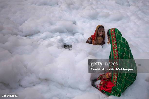 Hindu devotees take a dip in the waters of River Yamuna amid toxic foam caused by pollution on the occasion of Chhat puja on November 10, 2021 in...