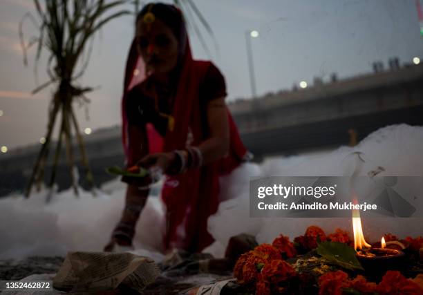 Hindu devotee takes a dip in the waters of River Yamuna amid toxic foam caused by pollution on the occasion of Chhat puja on November 10, 2021 in...