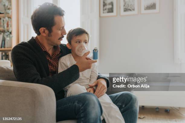 niño pequeño y su padre haciendo inhalación con nebulizador - nebulizador fotografías e imágenes de stock