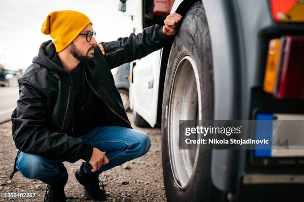 truck driver checks the truck - vrachtwagen banden stockfoto's en -beelden