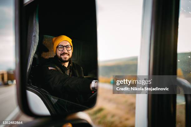 der lkw-fahrer benutzt das telefon - trucker stock-fotos und bilder