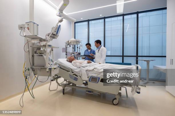 doctors checking on a patient at the hospital - medvetslös bildbanksfoton och bilder