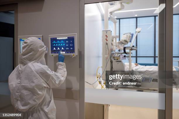 medico che controlla i segni vitali di un paziente ricoverato in ospedale per covid-19 - stato di emergenza foto e immagini stock