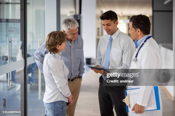pacientes que hablan con el gerente del hospital sobre su cobertura de seguro de salud - medical insurance fotografías e imágenes de stock