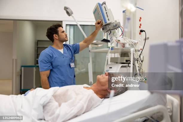 nurse at the hospital checking the vitals on a hospitalized patient - bewusteloos stockfoto's en -beelden
