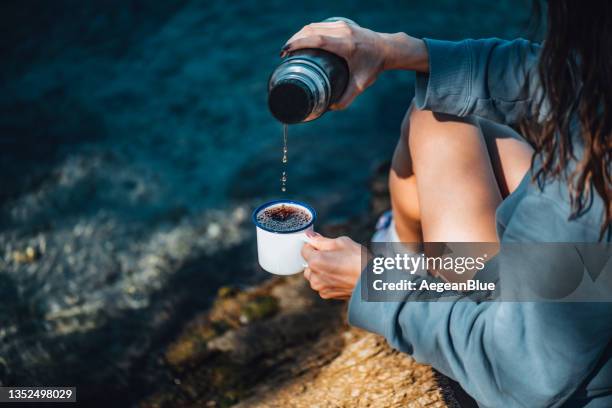 woman drinking coffee from her thermos on the beach - flask stock pictures, royalty-free photos & images