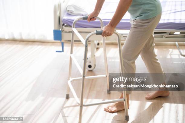 senior patient walking with walker. - looprek stockfoto's en -beelden