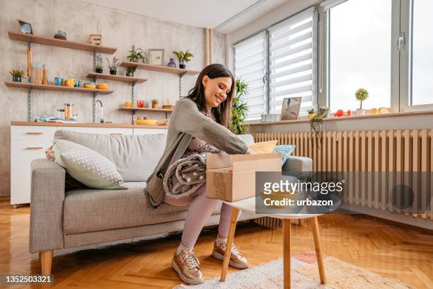 excited pregnant woman unpacking box after online shopping - receiving package stock pictures, royalty-free photos & images