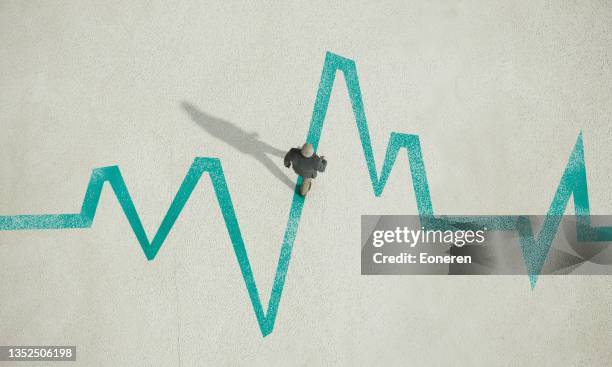 mann geht auf gemalten pulsspurendiagramm - pulslinie stock-fotos und bilder