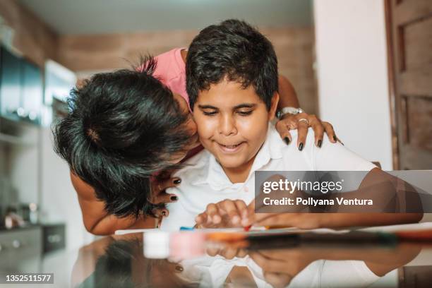 mother kissing the son - developmental disability stock pictures, royalty-free photos & images