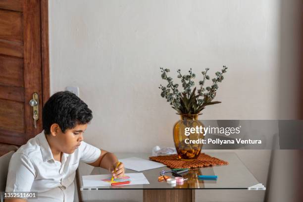 autistic boy drawing at home - sitting sideways drawing stock pictures, royalty-free photos & images