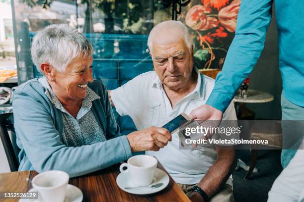 senior woman paying contactless with smart phone at the restaurant. - approaching bildbanksfoton och bilder