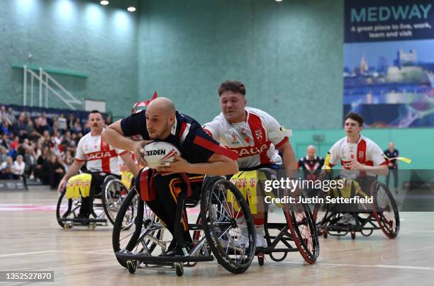 Jeremy Bourson of France breaks away from Tom Halliwell of England to score a try during the International Wheelchair Rugby League Test Series...