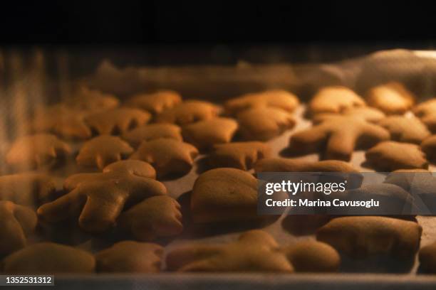 christmas cookies in the oven. - man baking cookies stock pictures, royalty-free photos & images