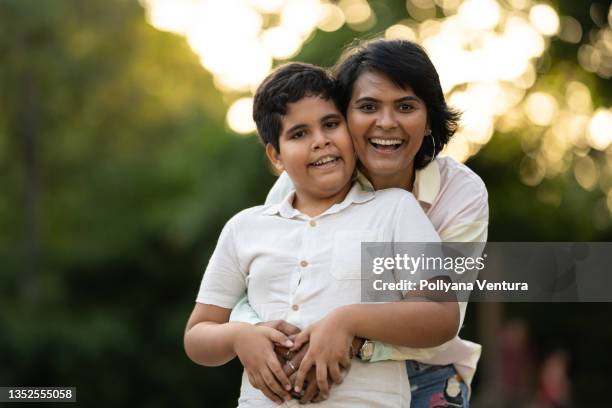 mother hugging son in the public square - asperger syndrome stock pictures, royalty-free photos & images