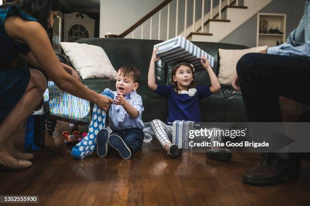 happy children opening gifts during hanukkah - hanukkah stock pictures, royalty-free photos & images