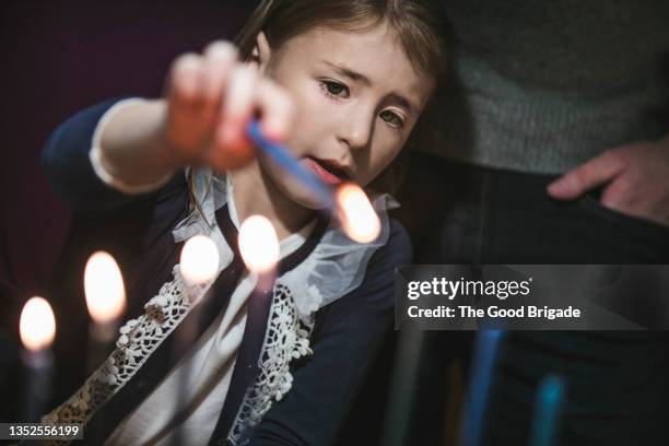 young girl lighting menorah - jewish tradition stock pictures, royalty-free photos & images