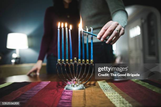 couple lighting menorah during hanukkah - menorah fotografías e imágenes de stock