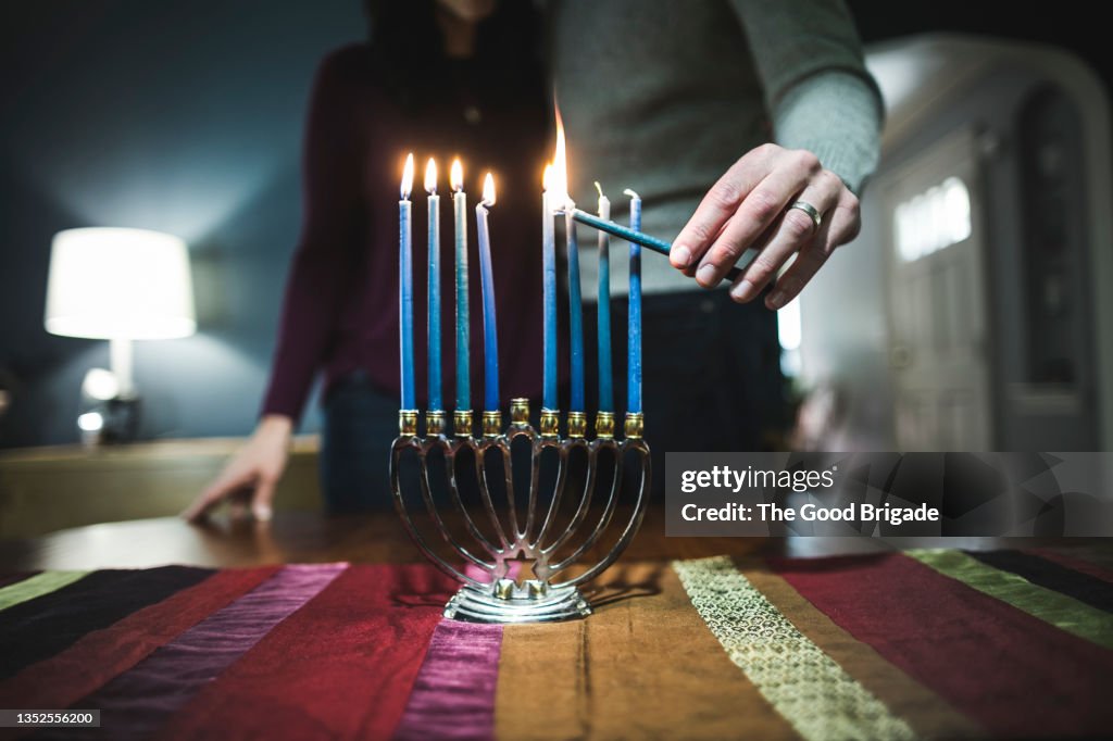 Couple lighting menorah during Hanukkah
