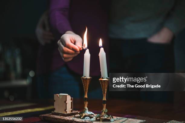 woman lighting shabbat candles - judía fotografías e imágenes de stock