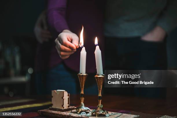 woman lighting shabbat candles - ceremony stockfoto's en -beelden