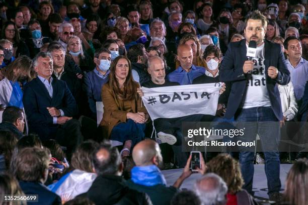 Deputy candidate Martin Tetaz speaks to supporters as former president of Argentina and opposition leader Mauricio Macri listens next to, deputy...