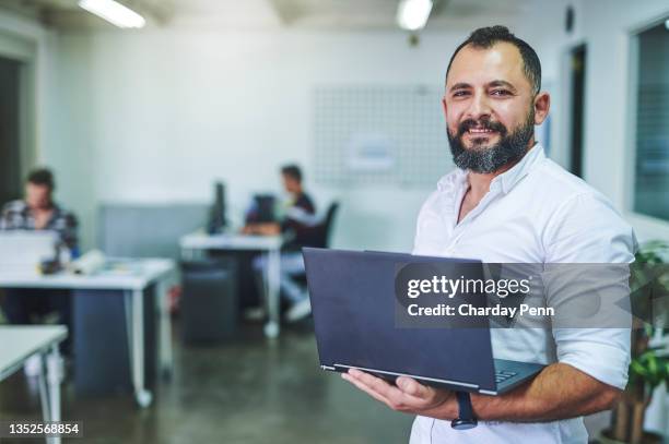 aufnahme eines geschäftsmannes, der seinen laptop in seinem büro hält - emirati guy using laptop stock-fotos und bilder