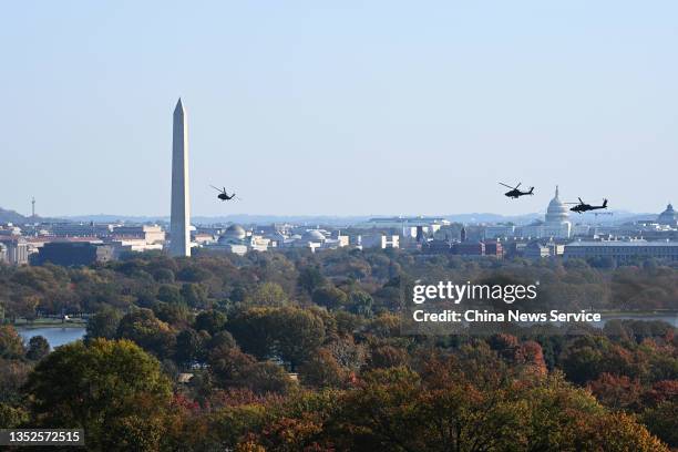 Helicopters fly in front of the Washington Monument on November 10, 2021 in Washington, DC.