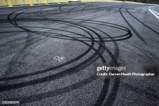 Thick black rubber tyre tracks left by spinning Pirelli P Zero tyres on Sebastian Vettel's Red Bull Racing RB9 racing car as he performed spinning...