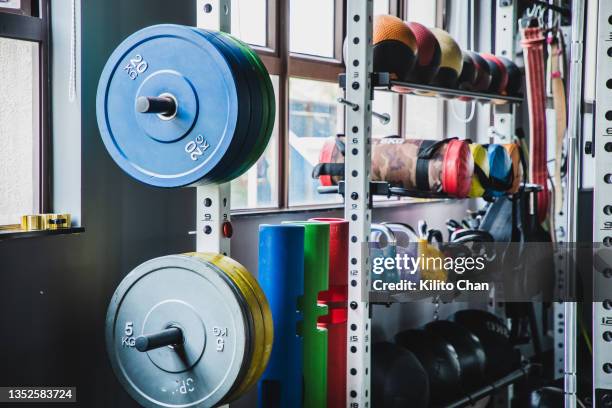 medicine balls, kettlebells and variety of weight training equipments on a rack - weight training stock pictures, royalty-free photos & images