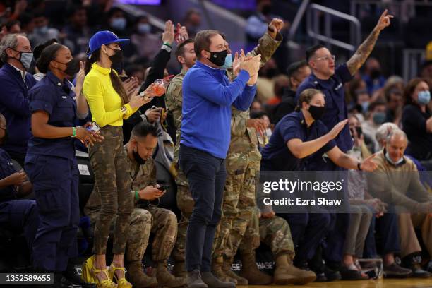 Golden State Warriors owner Joe Lacob and wife Nicole Curran sit next to members of the military during the Golden State Warriors game against the...